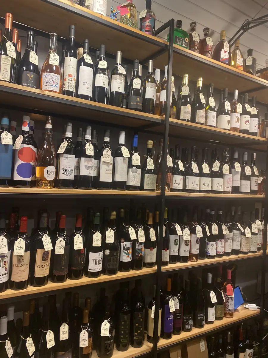 Rafovi puni boca vina, svaka sa papirnom etiketom oko grlića